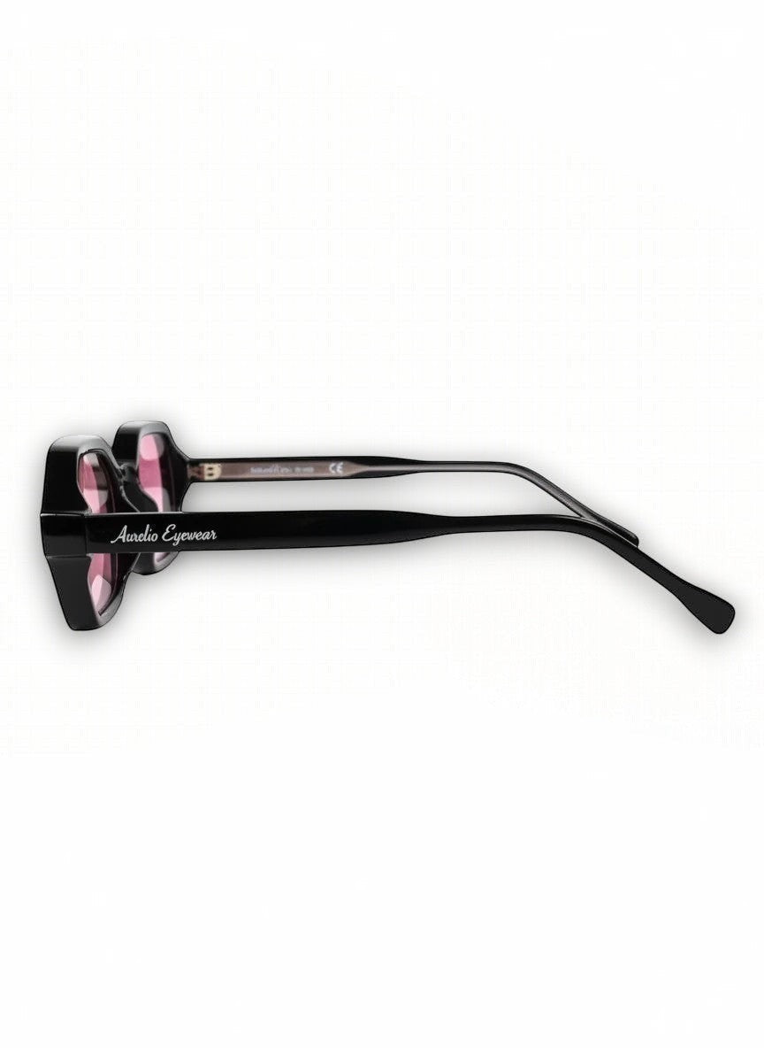 Zijaanzicht van de zwarte Aurélio Eyewear C3 zonnebril met roze glazen en merklogo op de pootjes.